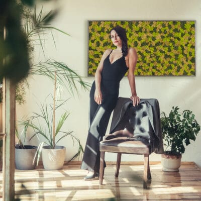 Beautiful girl model dressed in black clothes standing near armchair in loft style interior